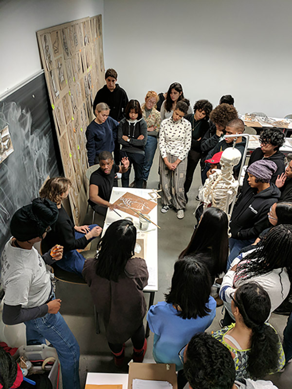 Vaughn Lewis AR'17(seated at desk) teaching a Portfolio Prep class