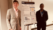 Photo of George and Zephaniah. In between them is a poster with research presented at the BioMap Consortium Fall 2024 Industry Day.