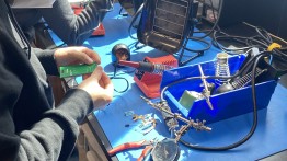 image of the solder station at makerspace, with a student trying their hand at soldering a PCD board 