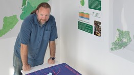 Sam Keene with some results of the 2018 Data Science for Social Good class. Photo by Photo by Marget Long/The Cooper Union