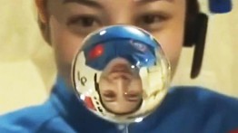 Wang Yaping demonstrates the behavior of a ball of water in space during a lecture broadcast to students on Earth in 2013. Photo: SCMP Pictures.