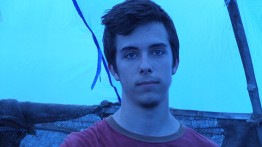 Harrison Cullen inside a shelter he helped build in Ghana covered in blue plastic. Photo by Peter North A'15