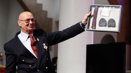 Henry Rey holds up Dabney Montgomery's shoe soles, tie and notebook from his march with Martin Luther King