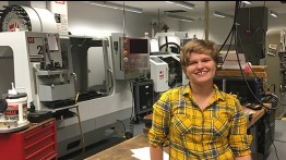 Jenna Scott in front of Cooper's CNC milling machine