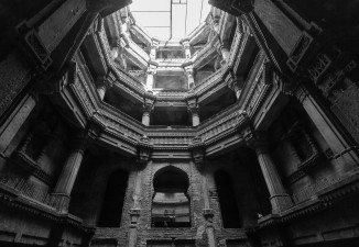 Pillared galleries with intricately carved parapets encircling a central pool in Rudabai vaav. 