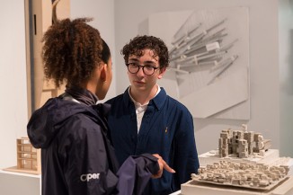 Aidrianos Efthymiadis AR'20 speaks with a friend in the Design IV Spring Semester showcase